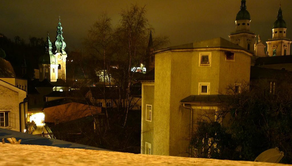 Aussicht vom Sternenpfad auf die erleuchtete Innenstadt Salzburgs